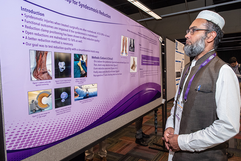 Foot and ankle surgeon reading research poster